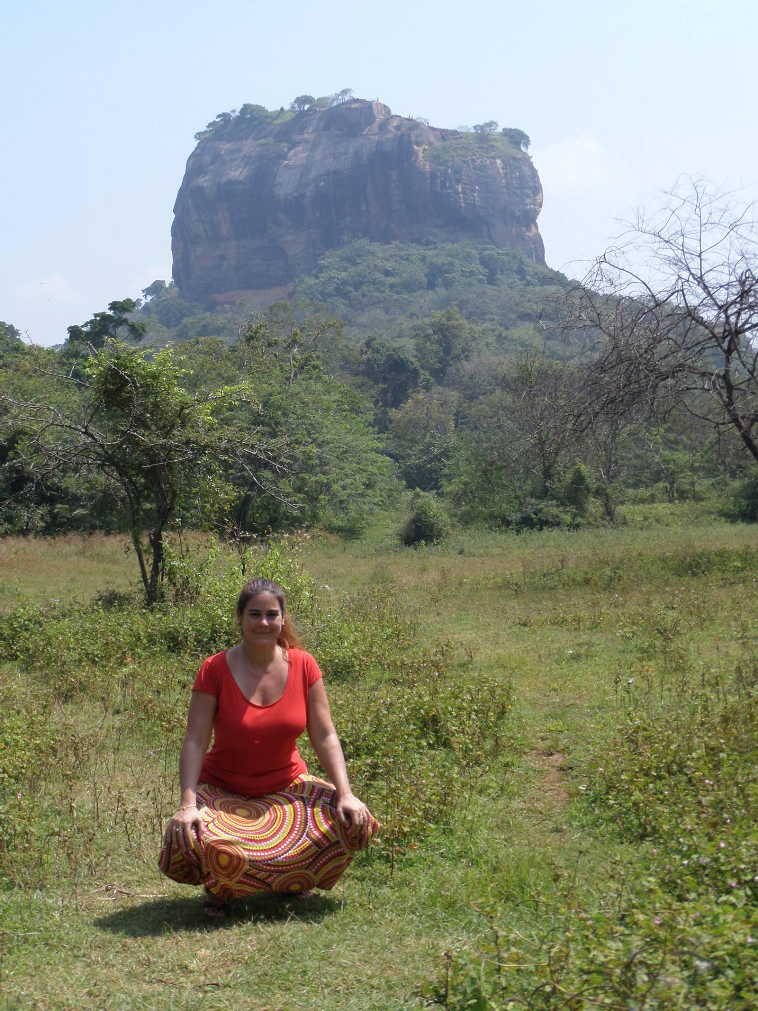 Claire en posture de méditation au Sri Lanka, devant le rocher de Sigiriya, symbole de sagesse et de puissance naturelle.